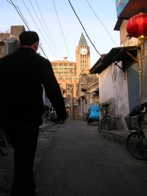 Het contrast: Een klein steegje, met op de achtergrond de grote commerciele gebouwen